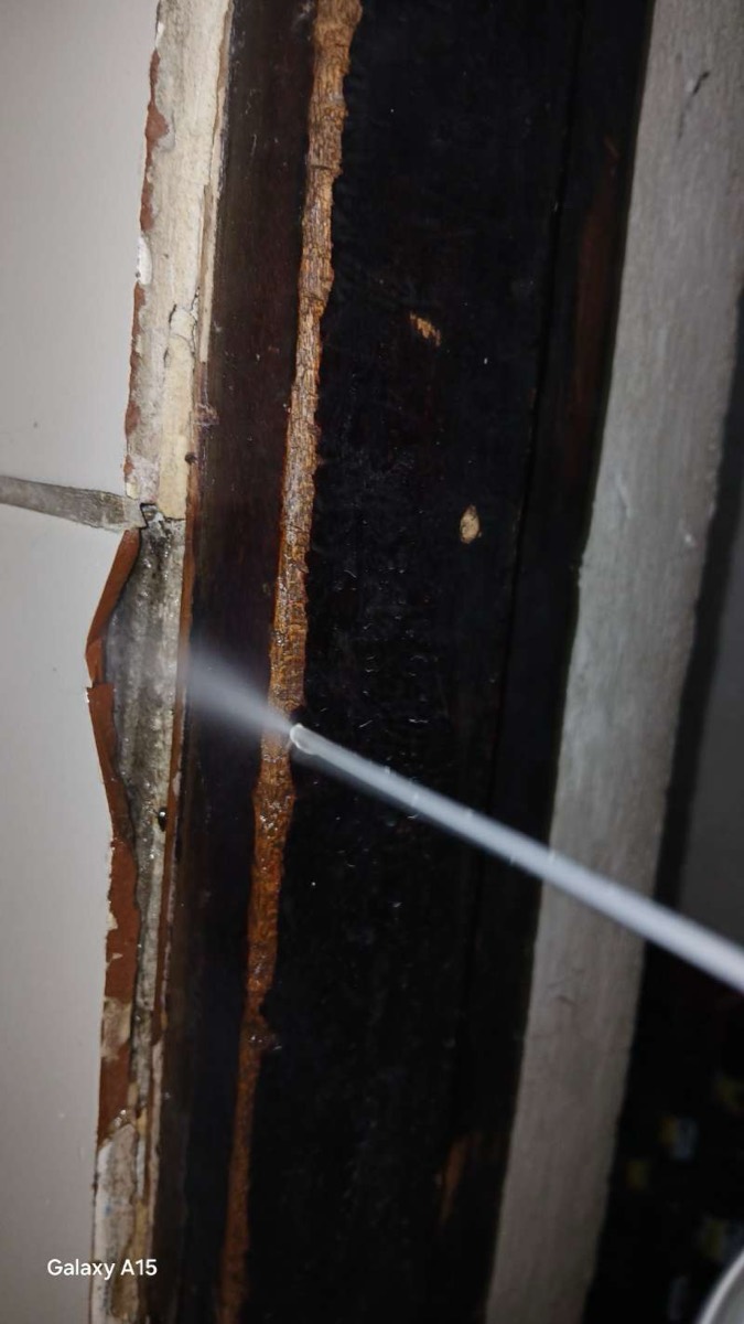 Termiticide injection into a wood frame damaged by termites