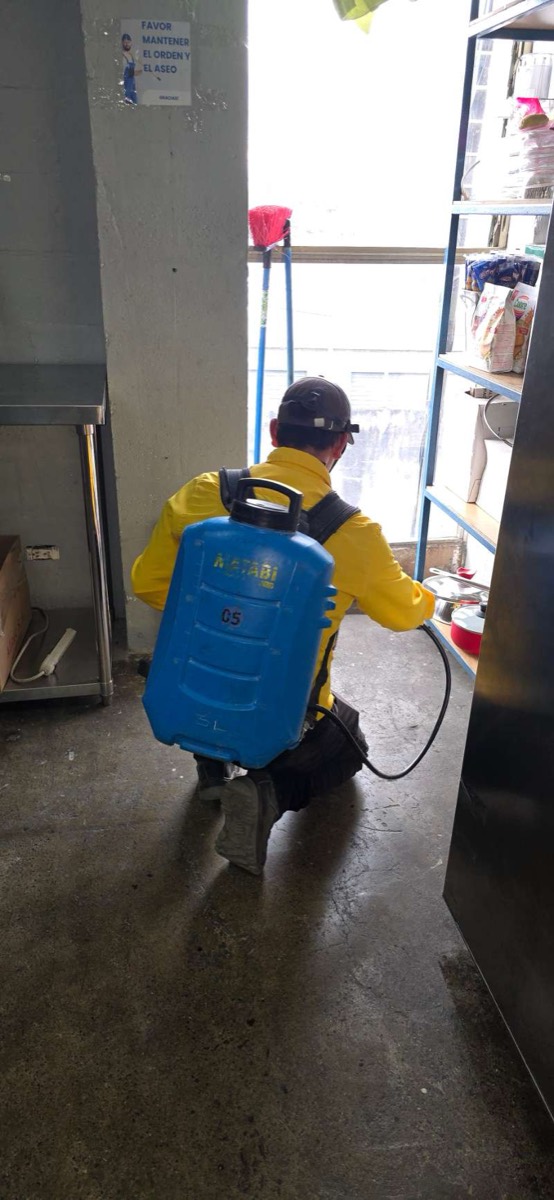 EcoPlagas technician applying product in a commercial space