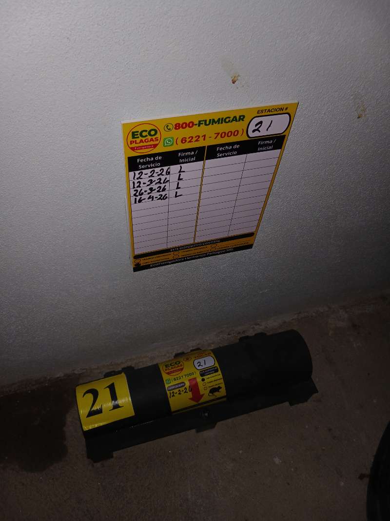 Estación de control de roedores número 21 rotulada, con su bitácora de servicio firmada en la pared