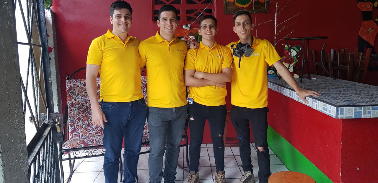 Los cuatro hermanos fundadores de EcoPlagas con camisas amarillas
